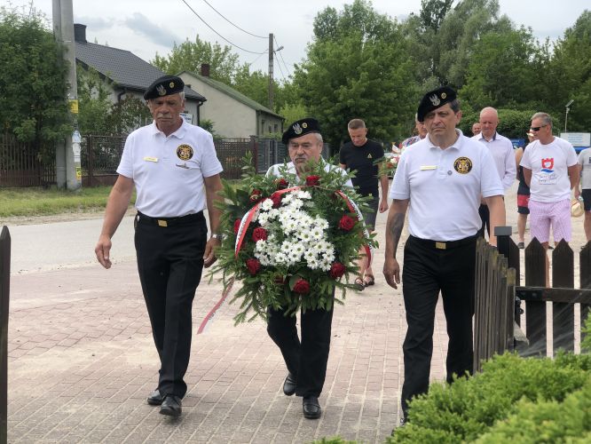 członkowie stowarzyszenia składają kwiaty pod pomnikiem